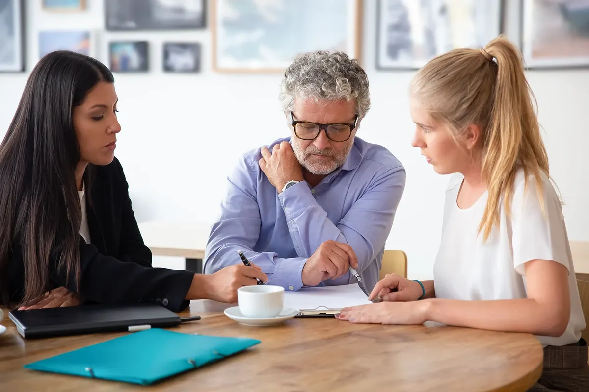 Legal advisor explaining documents to a father and adult daughter
